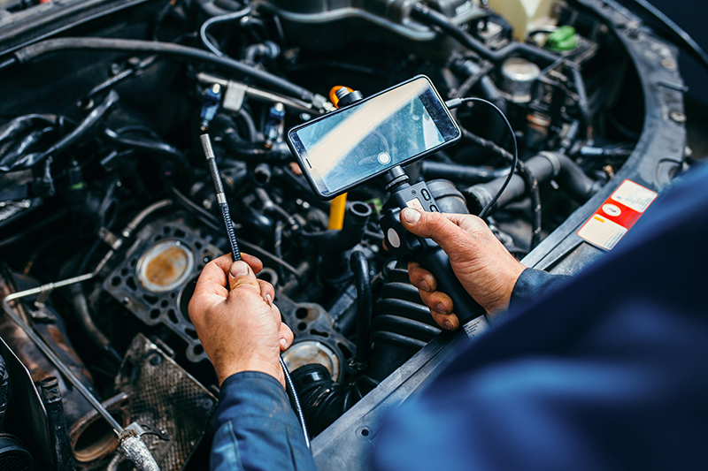 Bridgeton GMC certified technician checking engine components with inspection device